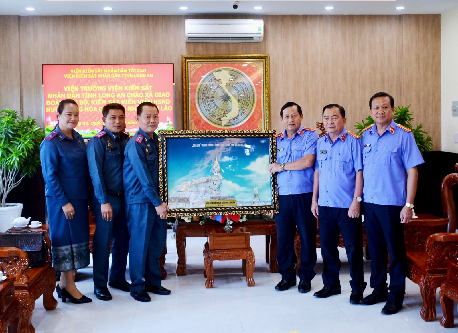 Procurator General of the Provincial People's Procuracy - Truong Van Nghi presents souvenirs to the delegation of the People's Procuracy of Lao PDR