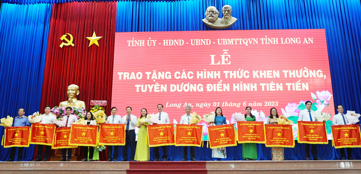 Đại diện huyện Bến Lức, Chủ tịch UBND huyện - Lê Thành Út (bìa phải) nhận cờ thi đua của UBND tỉnh