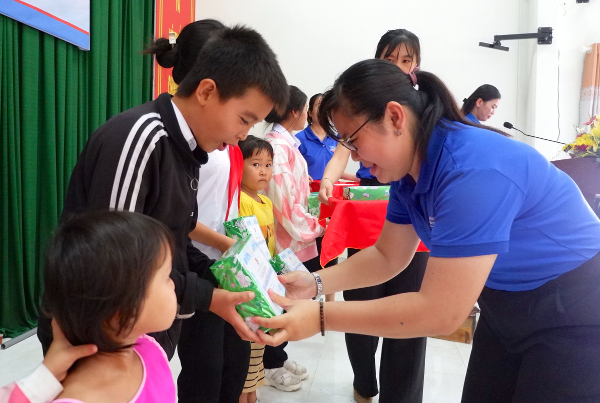 Chị Nguyễn Thị Như Ngọc tặng quà cho học sinh có hoàn cảnh khó khăn trong chương trình Đồng hành người bạn vùng biên tại thị xã Kiến Tường