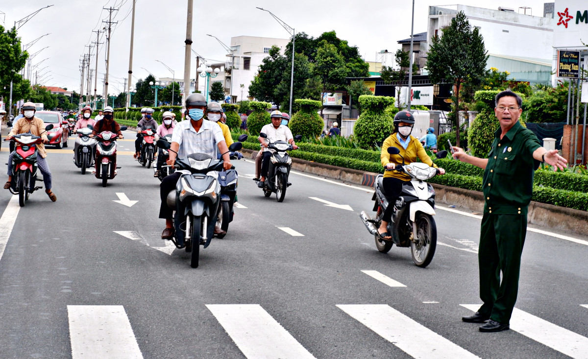 Cựu chiến binh tham gia điều tiết giao thông trước cổng trường THCS Lý Tự Trọng (phường 4, TP.Tân An)