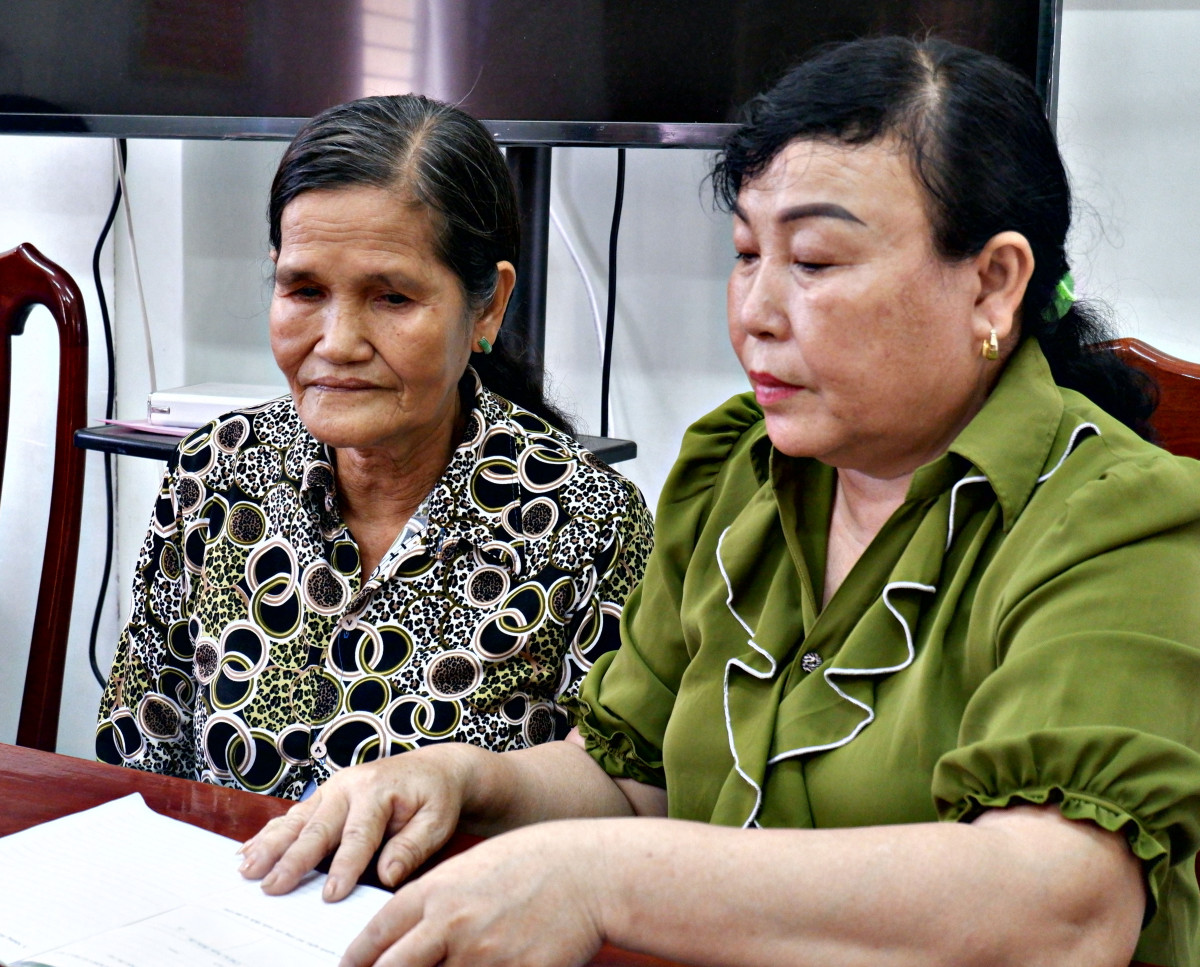 Bà Đoàn Thị Kim Anh (bên phải) hướng dẫn người dân tiếp cận nguồn vay vốn ưu đãi từ Phòng Giao dịch Ngân hàng Chính sách xã hội huyện 