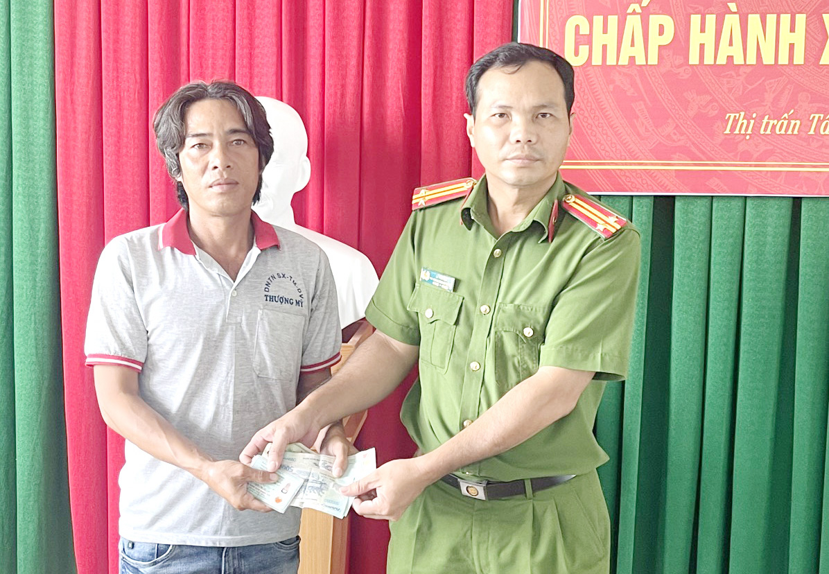 Công an thị trấn Tân Thạnh trao lại chiếc bóp cùng giấy tờ và tiền cho anh Nguyễn Văn Hoàng