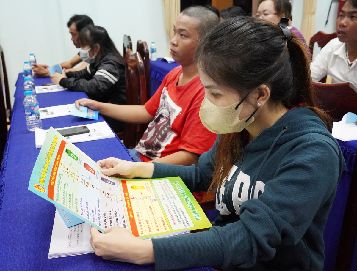 Công nhân, lao động xem tờ hướng dẫn phân loại rác sinh hoạt tại nguồn