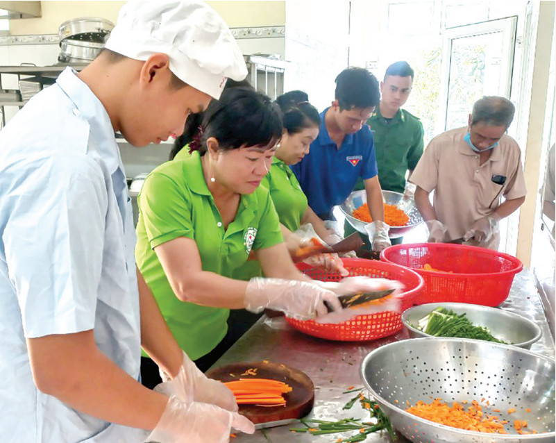 Các thành viên tham gia mô hình Cháo nghĩa tình (do Hội Chữ thập đỏ xã Bình Hiệp, thị xã Kiến Tường phối hợp Đồn Biên phòng Cửa khẩu Quốc tế Bình Hiệp tổ chức chuẩn bị nguyên liệu nấu cháo