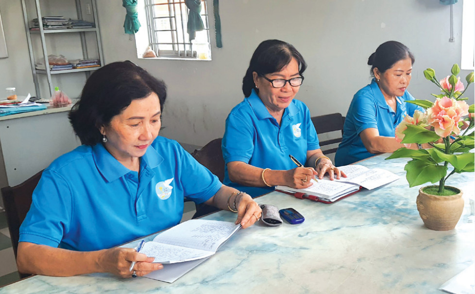 Trong những cuộc họp, bà Dương Thị Hồng Thu (bìa trái) thường ghi chép lại những nội dung liên quan đến kiến thức pháp luật để làm tốt hơn vai trò của mình
