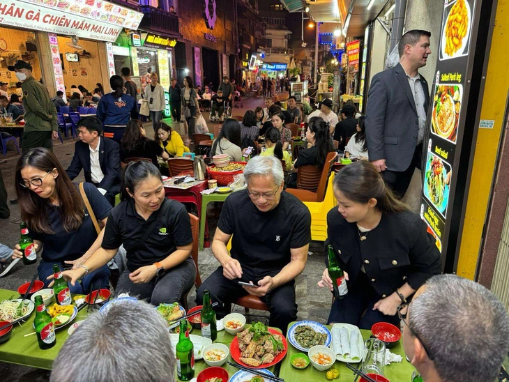 Ông Jensen Huang (giữa) thưởng thức món ăn và bia Việt Nam trên vỉa hè - Ảnh: HAT