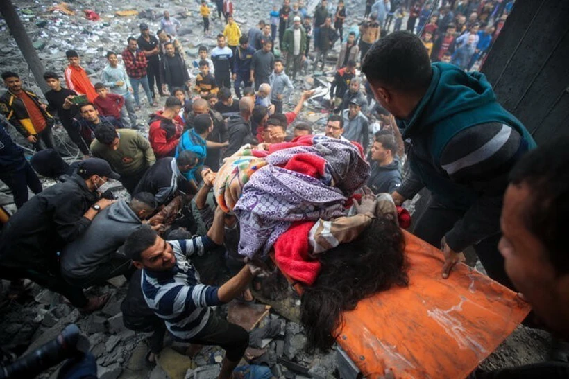 Chuyển người thiệt mạng trong cuộc không kích của Israel tại Dải Gaza. (Ảnh: IRNA/TTXVN)