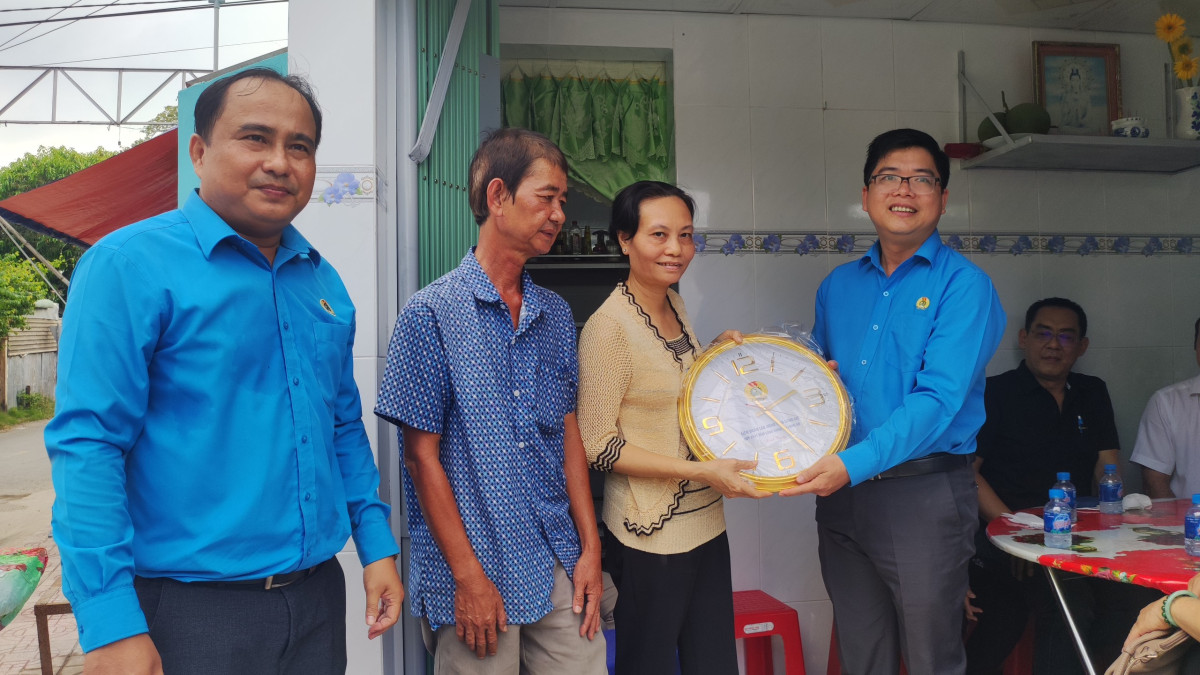 Phó Chủ tịch Liên đoàn Lao động tỉnh - Nguyễn Hoài Thanh (bìa phải) và Phó Chủ tịch Liên đoàn Lao động TP.Tân An - Trần Văn Hòa (bìa trái) tặng quà, chúc mừng đoàn viên được trao Mái ấm Công đoàn