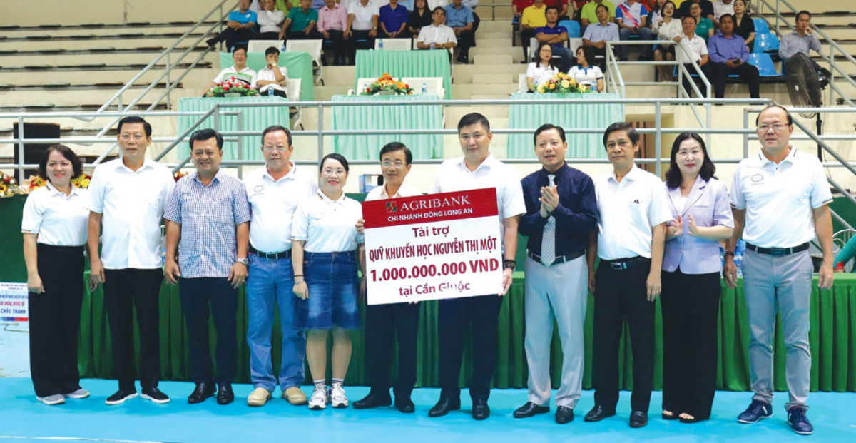Giám đốc Agribank chi nhánh Đông Long An - Huỳnh Minh Tuấn (thứ 5 phải qua) trao 1 tỉ đồng tài trợ Quỹ Khuyến học Nguyễn Thị Một