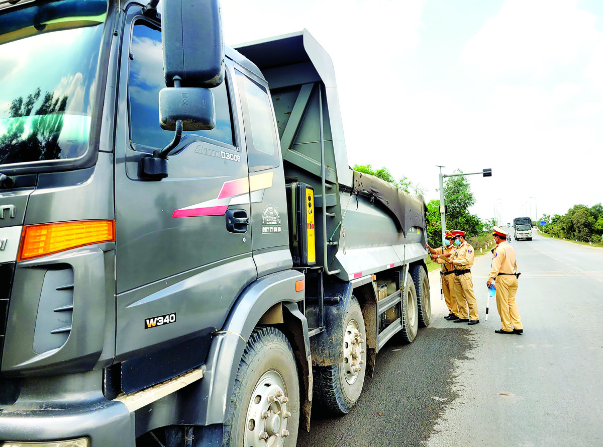 Cảnh sát giao thông kiểm tra xe tải chở hàng hóa về việc chấp hành quy định trọng tải
