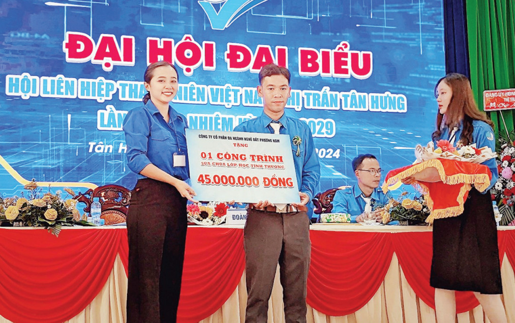 Chị Nguyễn Ngọc Yến (phường 5, TP.Tân An) trao bảng tượng trưng hỗ trợ kinh phí cho lớp học tình thương tại thị trấn Tân Hưng, huyện Tân Hưng