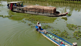 Mùa nước cạn, người dân bơi xuồng giăng lưới cá trên sông