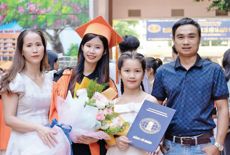 Chị Lê Thị Tuyết Nhi (xã Hải Hưng, huyện Hải Lăng, tỉnh Quảng Trị) chụp ảnh cùng gia đình trong lễ tốt nghiệp