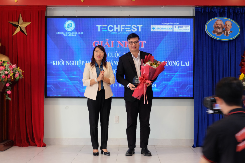 Phó Giám đốc Sở Khoa học và Công nghệ tỉnh Long An - Hồ Thị Diệp Thuý trao giải Nhất cho Dự án Công nghệ lên men trái nhàu để điều trị bệnh tiêu hoá của thí sinh Nguyễn Duy Lịch.