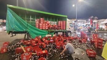 Xe tải thắng gấp, hàng trăm thùng bia bị đổ tràn xuống Quốc lộ 62