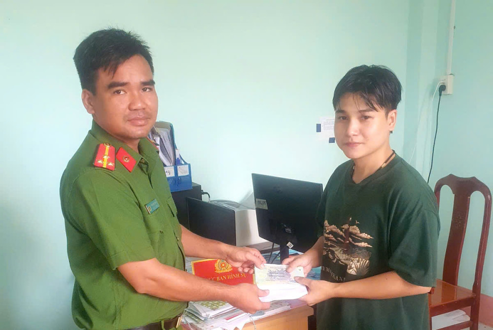 Anh Tạ Minh Lộc (23 tuổi) trao số tiền nhặt được cho Công an