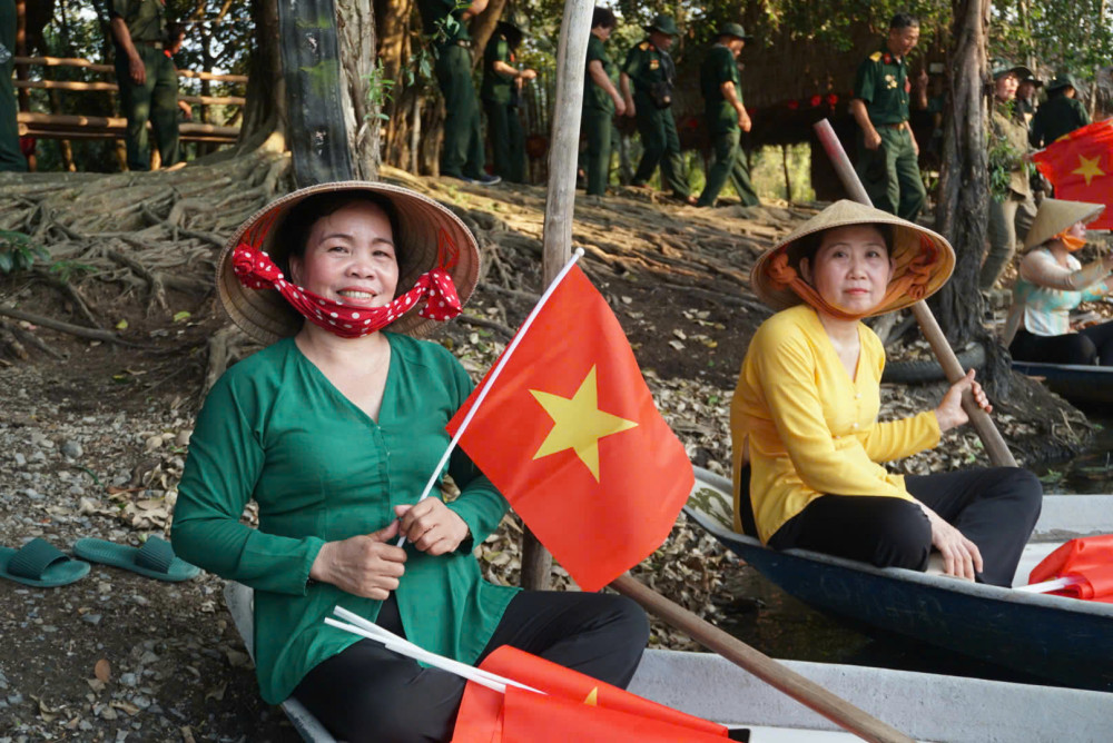 Hình ảnh phụ nữ Việt Nam duyên dáng trong tà áo bà ba cùng lá cờ Tổ quốc thể hiện nét đẹp truyền thống và niềm tự hào dân tộc trong không khí hoan hoan chào mừng đại lễ 30/4