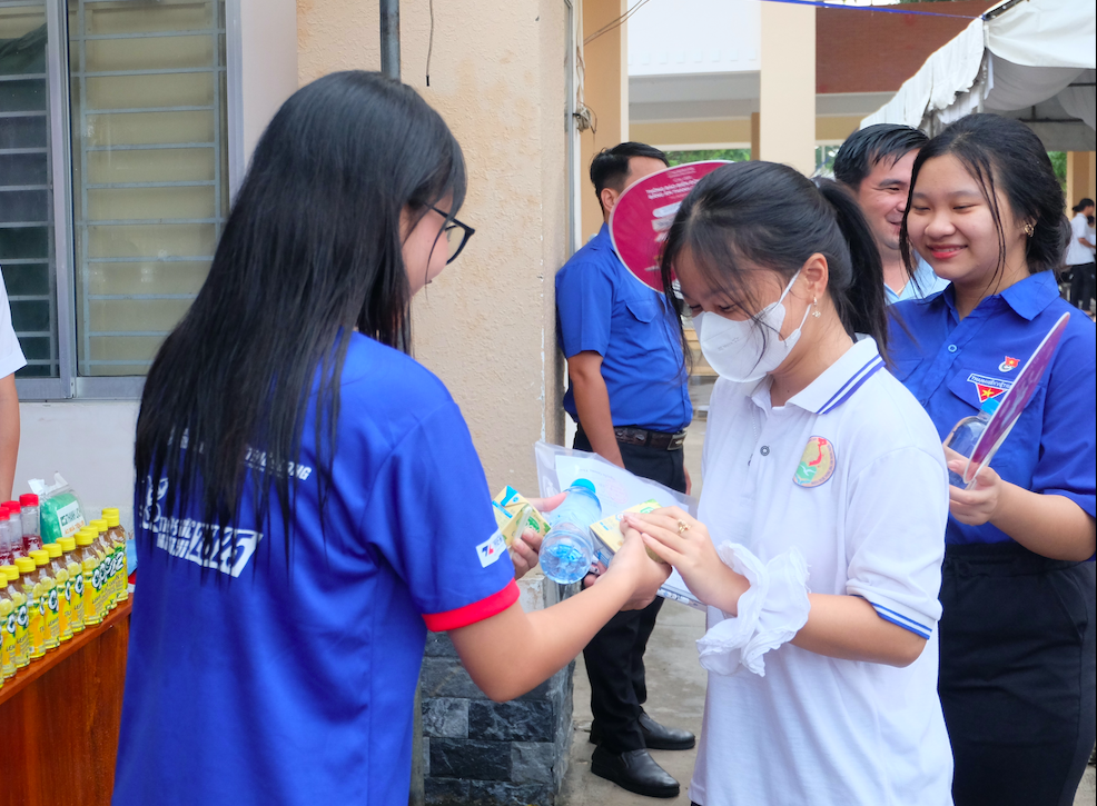 Tình nguyện viên phát sữa, nước uống cho thí sinh trước khi vào phòng thi