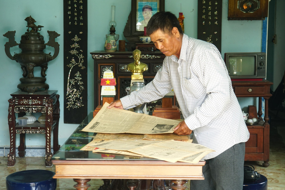 Ông Nguyễn Văn Nhứt nâng niu những tờ báo cũ đã mua được