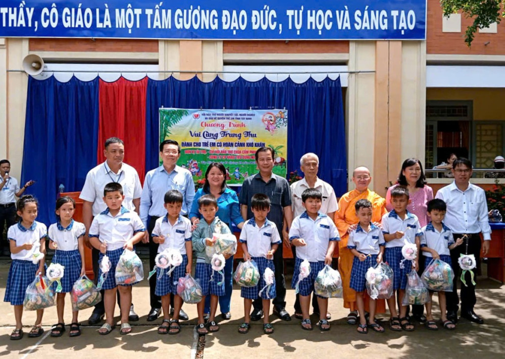 Lãnh đạo Sở Giáo dục – Đào tạo tỉnh và các thành viên trong đoàn tặng quà cho các em học sinh có hoàn cảnh khó khăn