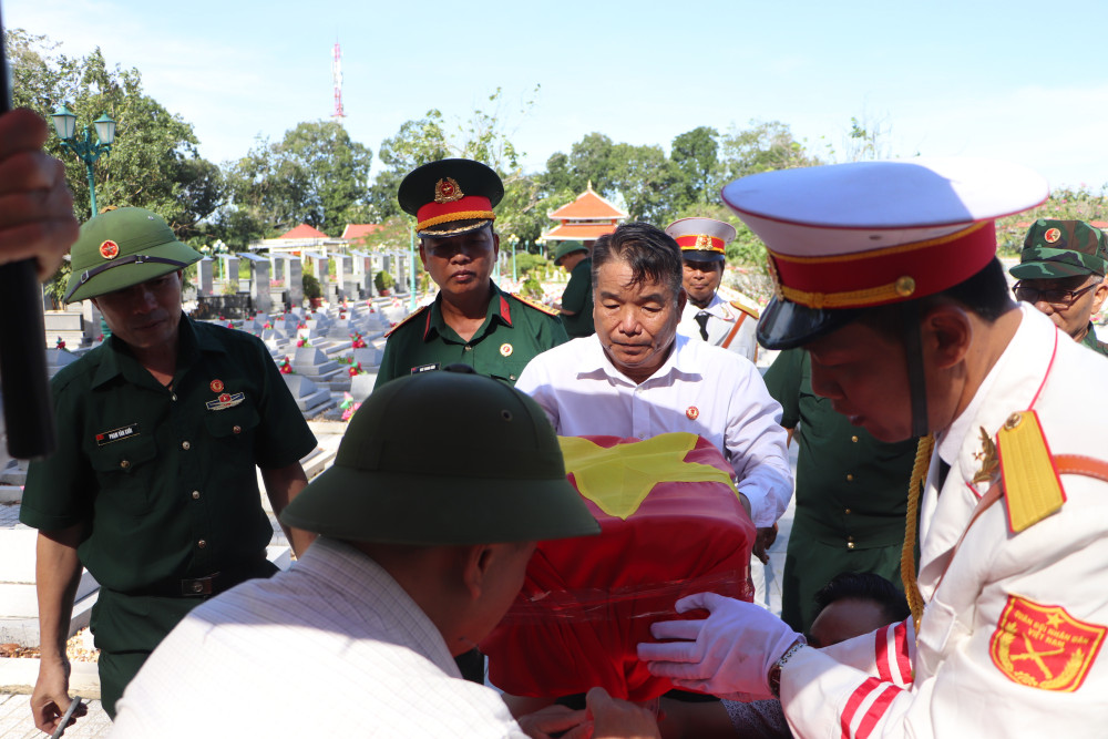 Các đơn vị chức năng và người thân của hai liệt sĩ thực hiện thủ tục cất bốc hài cốt.